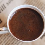 Cup of coffee resting on a folded newspaper