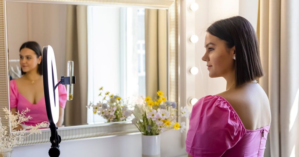 Creator recording a video with a phone mounted on a ring light